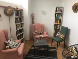 阿雷西費的住宿－Urban rest zone and coworking，客厅配有两把椅子、一张桌子和书架