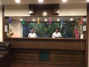 Dwóch mężczyzn stojących za barem w restauracji. w obiekcie IVY Studio w mieście Pune