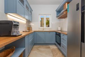 a kitchen with blue cabinets and a counter top at Luxury Villa Agape Ellita in Vir