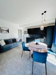 un salon avec une table et des chaises bleues dans l'établissement Residenza Cortemaggiore Luxury - Flexrent Immobiliare Abissinia, à Riccione