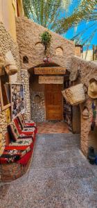 a stone building with a bench and a sign on it at Dream Lodge Siwa دريم لودج سيوة in Siwa