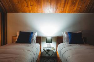 2 nebeneinander sitzende Betten in einem Schlafzimmer in der Unterkunft Cabanas do Pico 2a in São Roque do Pico