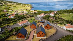 una vista aérea de un pueblo con casas y el océano en Cabanas do Pico 2b, en São Roque do Pico