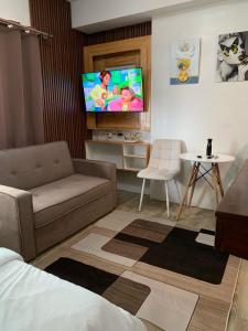 uma sala de estar com um sofá e uma televisão de ecrã plano em Urban Haven with City Skyline View in Bacolod City em Bacolod
