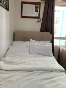 uma cama não feita num quarto com uma janela em Urban Haven with City Skyline View in Bacolod City em Bacolod