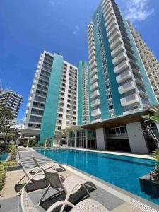 um grande edifício de apartamentos com piscina e cadeiras em Urban Haven with City Skyline View in Bacolod City em Bacolod