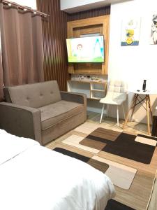 uma sala de estar com um sofá e uma televisão de ecrã plano em Urban Haven with City Skyline View in Bacolod City em Bacolod