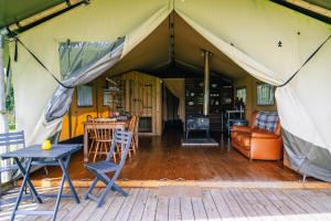 a tent with chairs and tables and a couch at Oak in Honiton