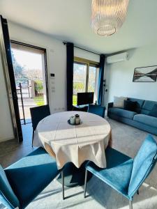 un salon avec une table et des chaises bleues dans l'établissement Residenza Cortemaggiore Luxury - Flexrent Immobiliare Abissinia, à Riccione