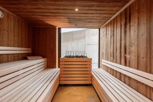 an empty sauna with wooden walls and benches at Kitzbühel Suites by ALPS RESORTS in Oberndorf in Tirol
