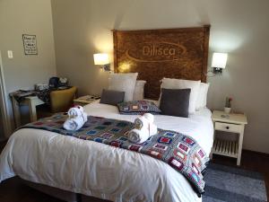 dos animales de peluche en una cama en una habitación de hotel en Dilisca Guesthouse, en Durbanville