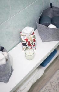 una mensola bianca con una candela e una scatola sopra di Flor Thermae&Relax a Montegrotto Terme