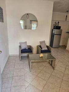 ein Wohnzimmer mit 2 Stühlen und einem Tisch in der Unterkunft Hermosa Suites #9 in the heart of PUNTA CANA in Punta Cana
