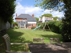 a yard with two chairs and a playground in front of a house at 3 Bed in Studland DC071 in Studland