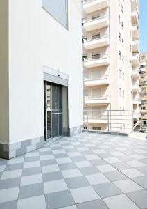 ein weißes Gebäude mit einer Seitentür in der Unterkunft LD Apartment in Vlorë