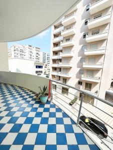 einen Balkon eines Apartmenthauses mit einem karierten Boden in der Unterkunft LD Apartment in Vlorë