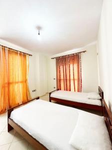 1 Schlafzimmer mit 2 Betten und einem Fenster in der Unterkunft LD Apartment in Vlorë