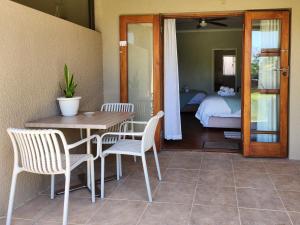 una habitación con mesa y sillas y un dormitorio en Dilisca Guesthouse, en Durbanville