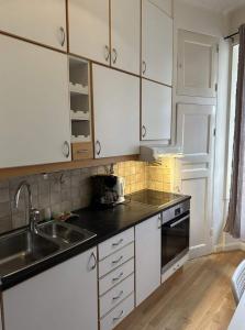 een keuken met witte kasten en een wastafel bij Luxury Apartment In City Centre in Göteborg