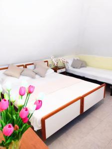 2 camas en una habitación con flores rosas en Hotel Ambasciata, en Cesenatico