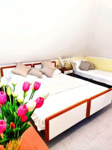 Dos camas en una habitación con un jarrón de flores en Hotel Ambasciata, en Cesenatico
