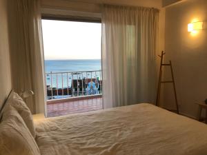 um quarto com uma cama e vista para o oceano em Sea View em Paço de Arcos