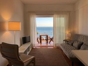 a living room with a couch and a view of the ocean at Sea View in Paço de Arcos