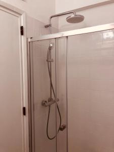 a shower in a bathroom with a glass door at Sea View in Paço de Arcos