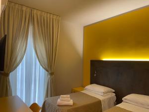 una camera d'albergo con due letti e una finestra di Hotel Lukas a Viareggio