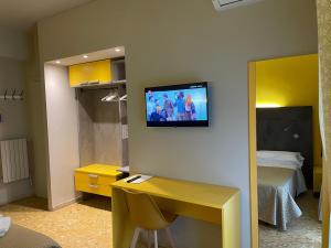 una camera d'albergo con TV a parete di Hotel Lukas a Viareggio