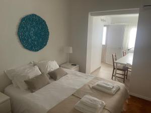 een slaapkamer met een wit bed en 2 handdoeken bij Inncork Guesthouse in Ponte de Sor