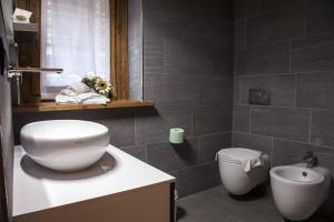 ein Badezimmer mit einem weißen Waschbecken und einem WC in der Unterkunft Baite Rosa in Alagna Valsesia