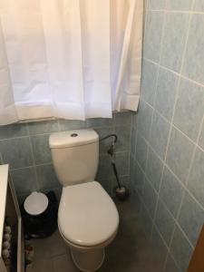 łazienka z białą toaletą i oknem w obiekcie Kris Pokoje w mieście Kajetany