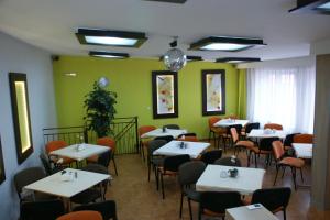 a dining room with tables and chairs and green walls at OWR Grażyna in Międzywodzie