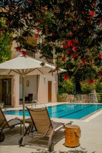 a pair of chairs and an umbrella next to a swimming pool at Villa Kalamitsi Luxury Villa in Apokorona Xania in Kariá