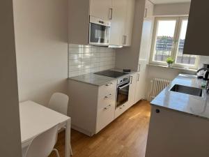 a kitchen with a sink and a stove top oven at Comfortable Apartment In Cozy Location in Gothenburg