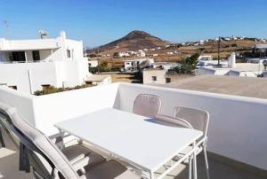 a white table and chairs on the roof of a building at Aeriko Apartment in Paros in Dhragoulás