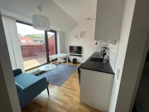 a kitchen and living room with a couch and a table at Private Terrace Apartment in Gothenburg
