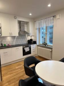 a kitchen with a table and some chairs and a table at Cozy And Confortable Apartment in Gothenburg