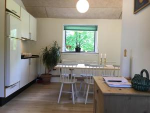 cocina con mesa, sillas y ventana en Jensens B&B en Egtved