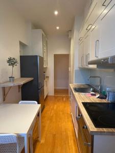 a kitchen with white cabinets and a black refrigerator at Luxury Apartment In City Centre in Gothenburg