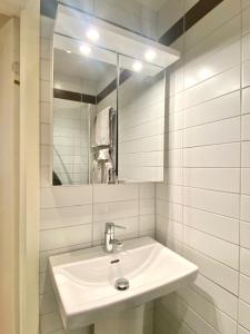 a white bathroom with a sink and a mirror at Luxury Apartment In City Centre in Gothenburg
