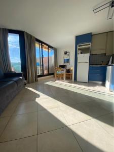 Una sala de estar con un sofá y una cocina. en La Perla del Mare, en Cannes