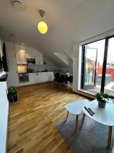 ein großes Wohnzimmer mit einem Tisch und einer Küche in der Unterkunft Luxury Apartment With Private Terrace in Göteborg