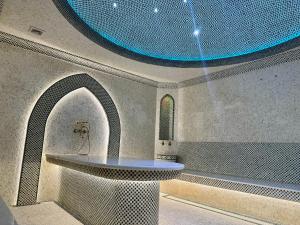 a room with a sink and a blue ceiling at Bentley Hotel Tashkent in Tashkent