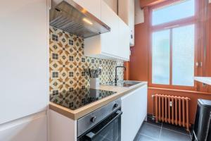 een keuken met een fornuis top oven naast een raam bij Charming and comfortable apartment near tramway in Marcq-en-Baroeul