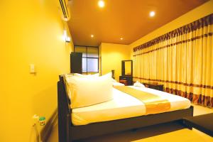 a bedroom with a bed with yellow walls at Gunners Club in Minneriya
