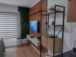 a living room with a desk and a shelf at Studio novo no Tatuapé ao lado do Metrô Carrão in São Paulo