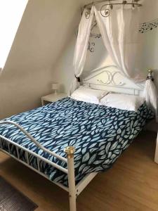 ein kleines Bett mit Baldachin in einem Zimmer in der Unterkunft Grand gîte familial in Ploumagoar