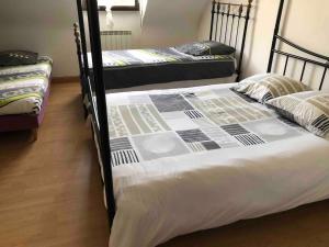 1 Schlafzimmer mit 2 Etagenbetten mit weißer Bettwäsche in der Unterkunft Grand gîte familial in Ploumagoar